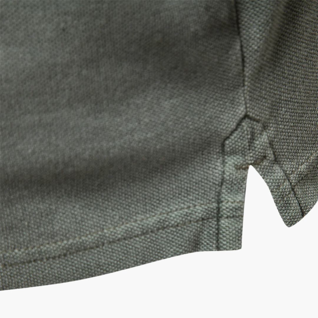 Side angle of tapered fit polo shirt highlighting streamlined silhouette and short sleeve construction