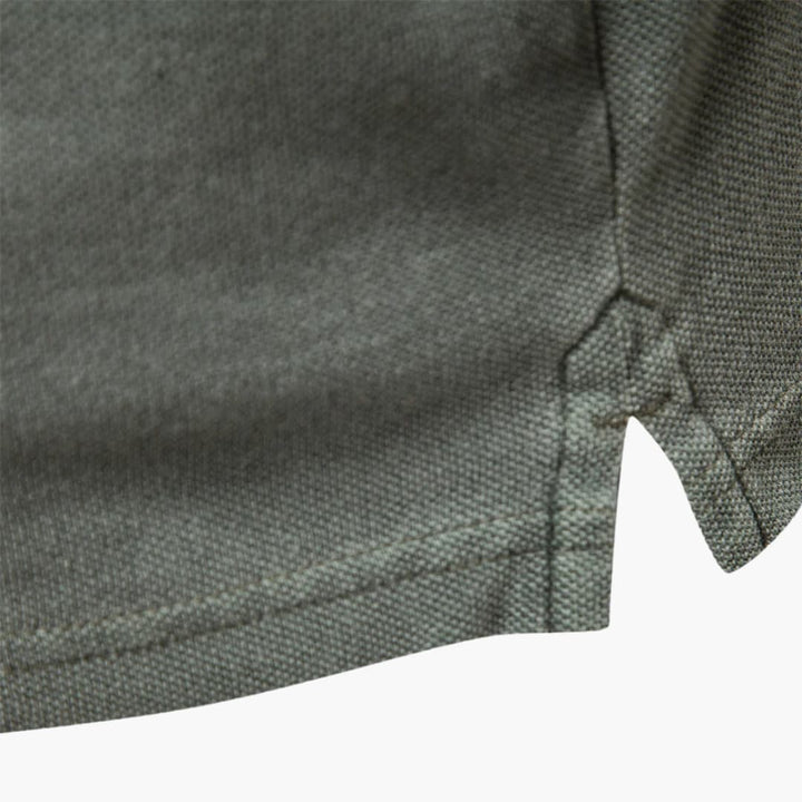 Side angle of tapered fit polo shirt highlighting streamlined silhouette and short sleeve construction