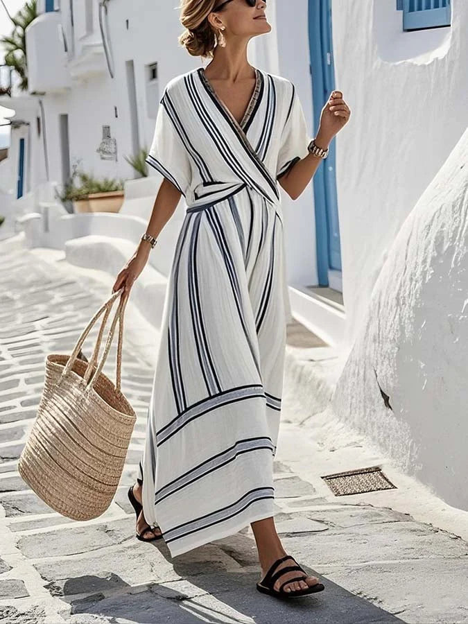 Woman wearing white Bohemian Woven Maxi Dress with navy stripes and wrap V-neckline on coastal street
