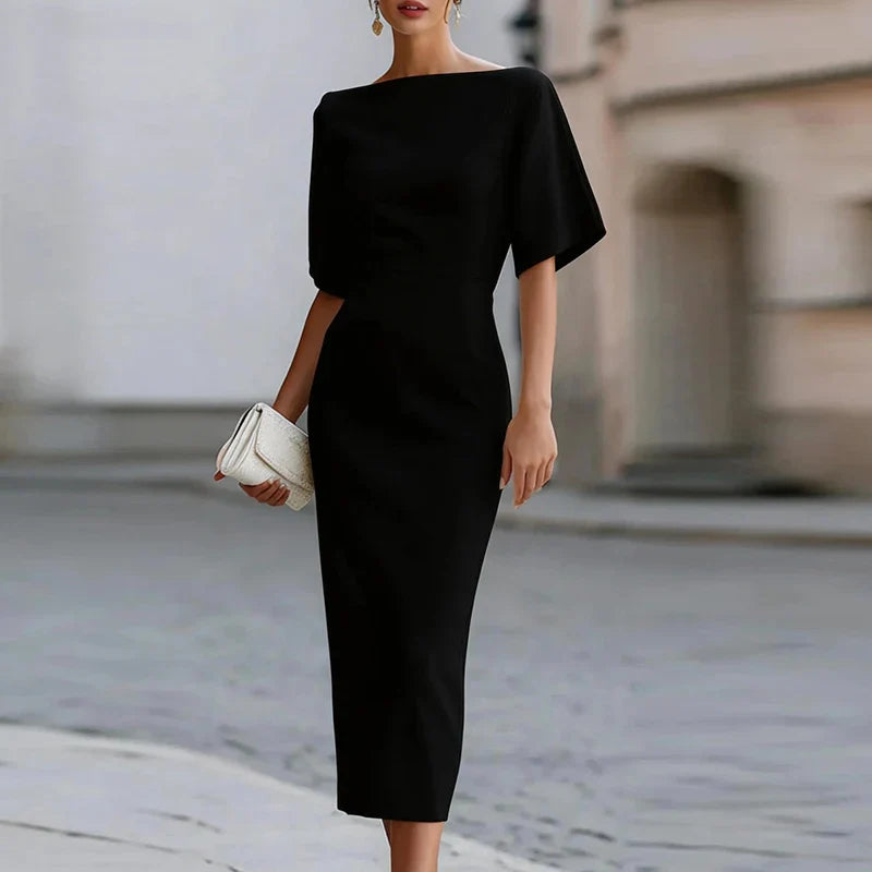 Full-length view of midi bodycon dress styled with clutch for evening event