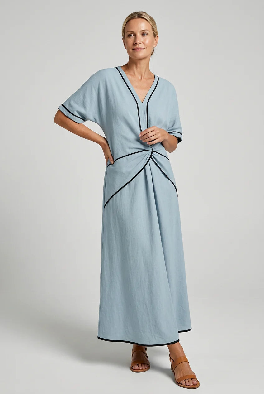 Side view of V-neck maxi dress showing A-line skirt and twist front waist detail