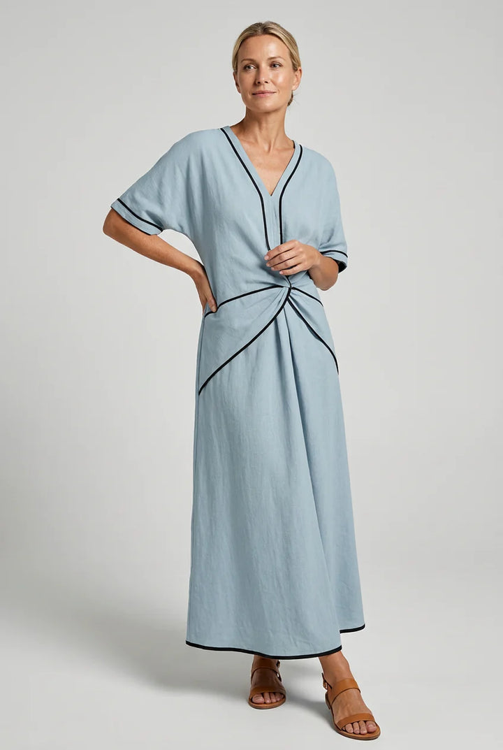 Side view of V-neck maxi dress showing A-line skirt and twist front waist detail