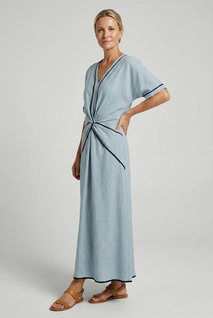 Close-up of twist front waist detail and contrast piping on maxi dress neckline