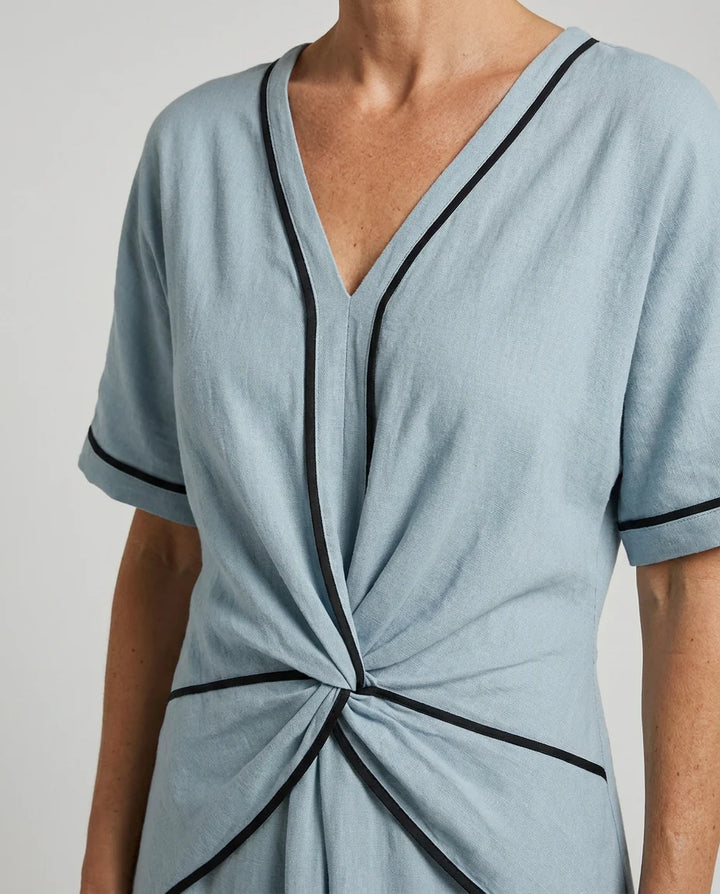 Woman styling V-neck maxi dress with straw tote for vacation wear