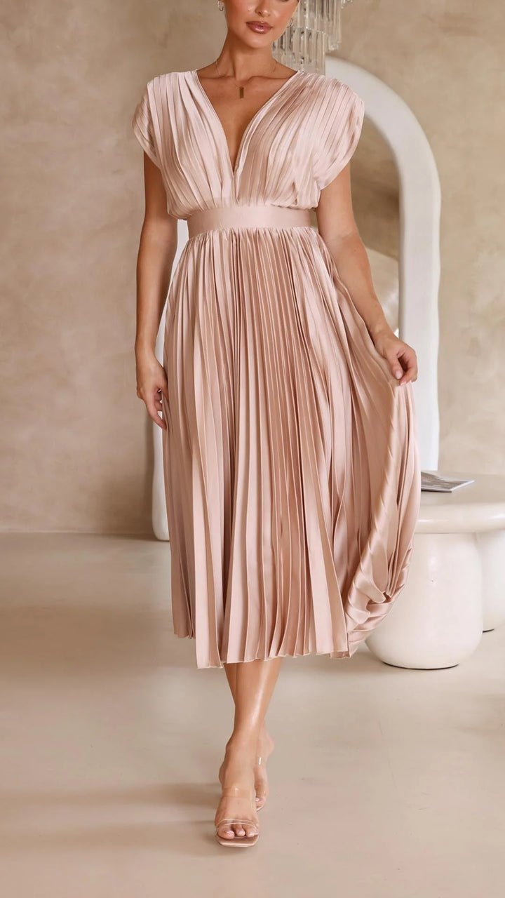 Close-up of pleating detail and high-waisted design on flowing maxi dress