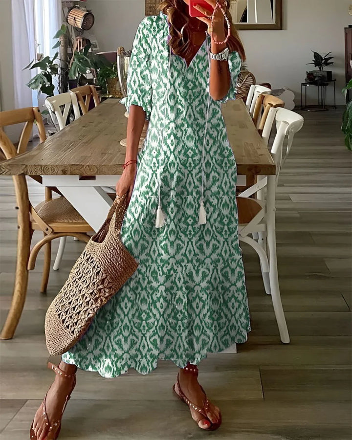 Close-up view of V-neckline and tassel tie detail on printed maxi dress