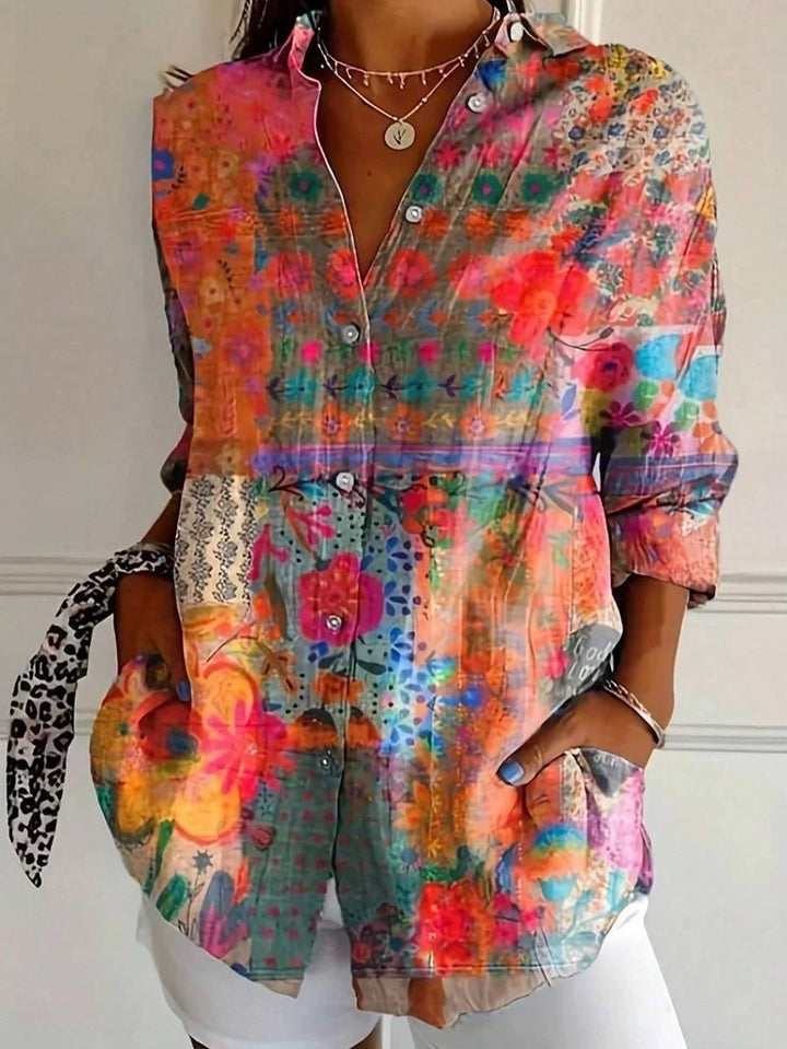 Close-up view of abstract floral print blouse showing button front closure and roll-tab sleeves