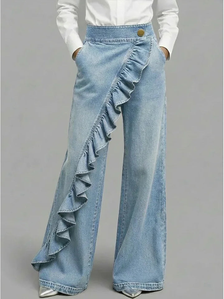 Close-up of asymmetrical ruffle detail on women's wide leg jeans with structured denim fabric
