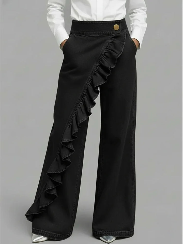 Full-length view of women's statement wide leg jeans paired with white shirt and silver heels