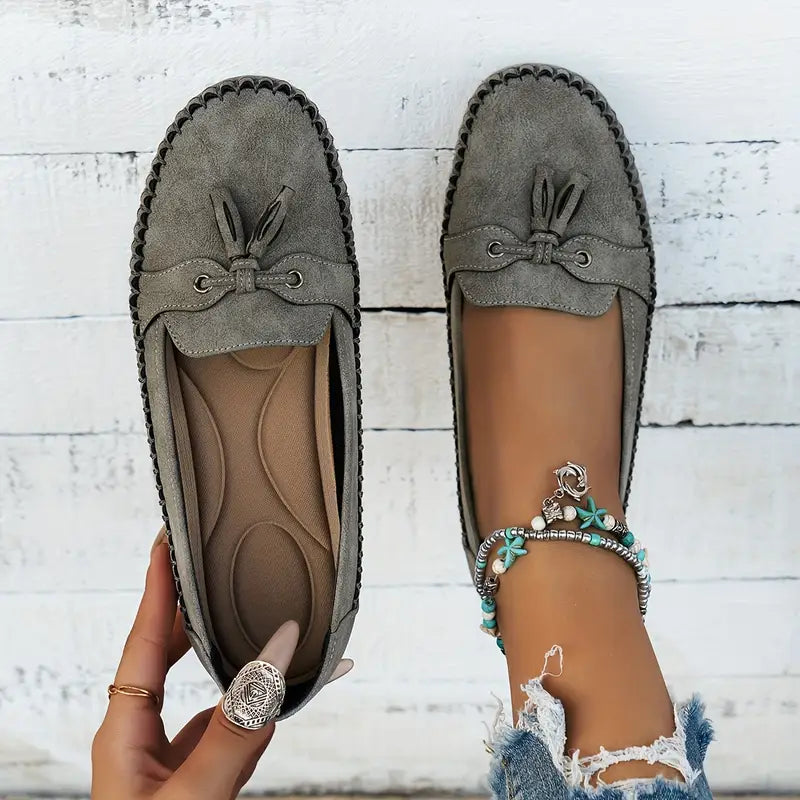 Women's slip-on loafers showing flexible synthetic material and supportive sole design