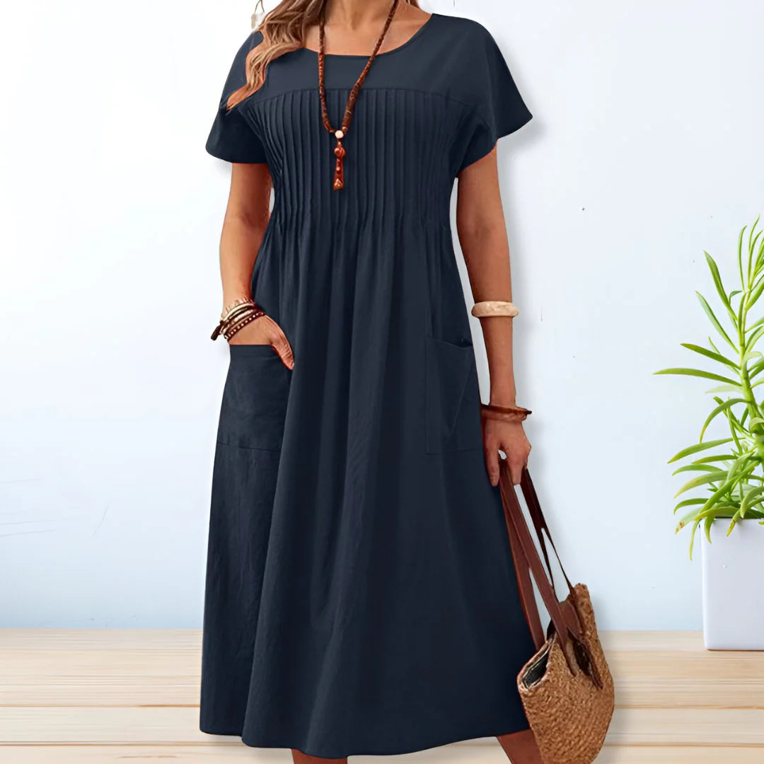 Mid-length cotton summer dress featuring vertical pintuck detail on bodice and functional side pockets