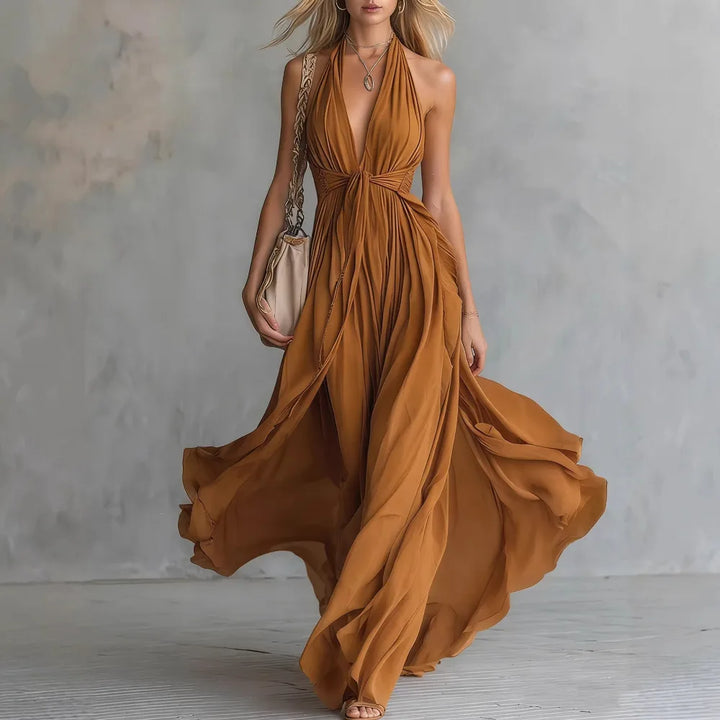 Back view of halter neck flowy evening dress with open back and flowing floor length hem