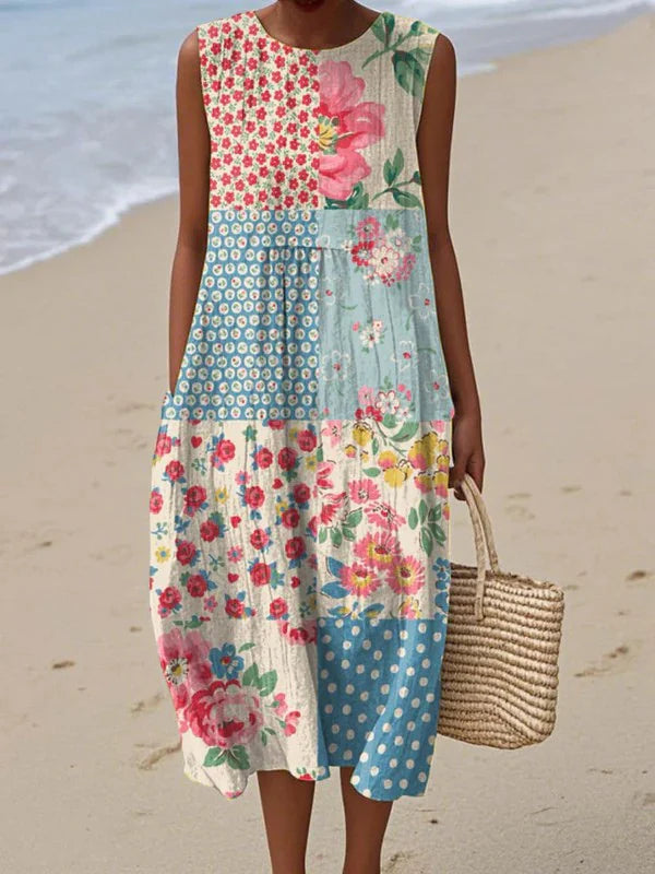 Woman wearing patchwork Summer Midi Dress with mixed floral and polka dot prints on beach setting