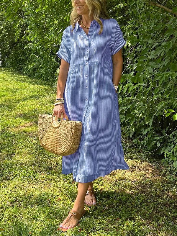 Woman wearing striped button-up midi dress with collared neckline and short sleeves in outdoor garden setting