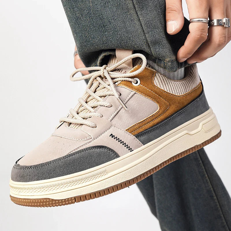 Side view of men's casual sneakers showing neutral patchwork panels and textured rubber sole