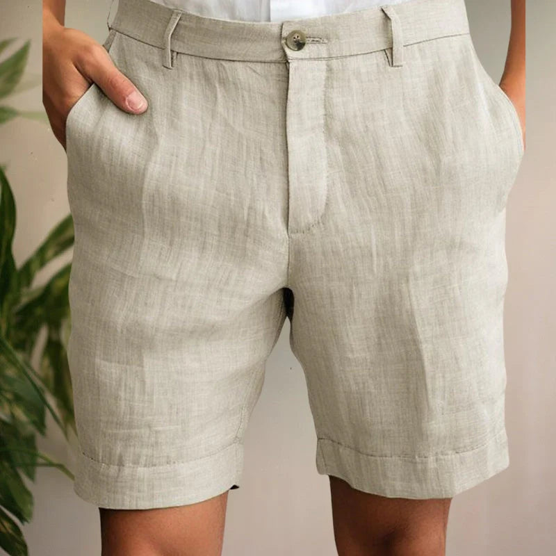 Men's tailored chino shorts in light beige with button closure, side pockets, and cuffed hem for summer wear