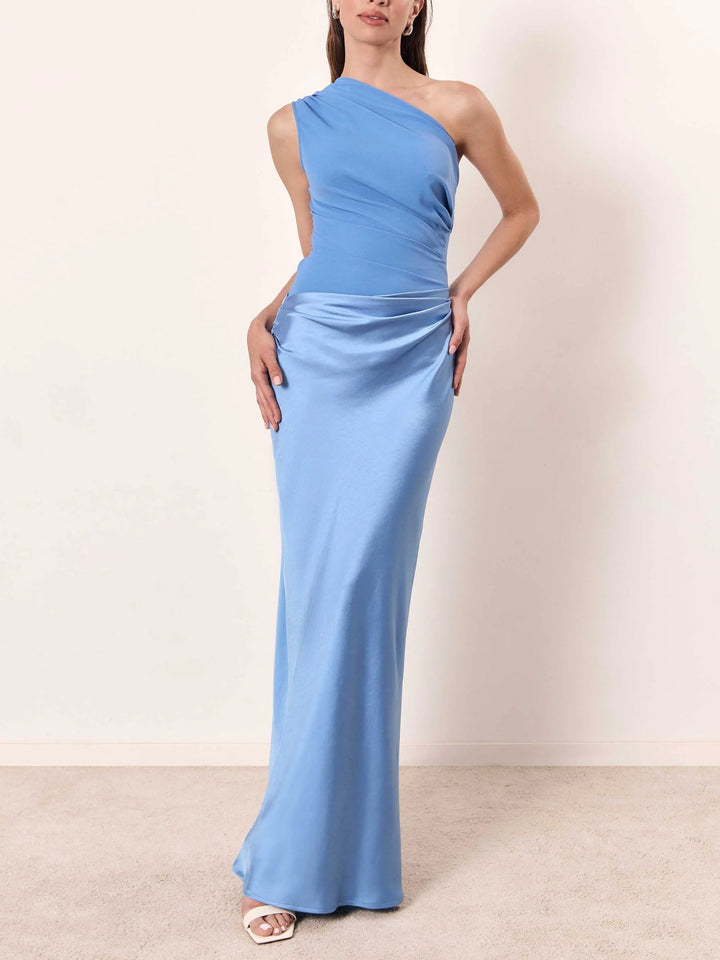 Side angle of one shoulder pleated party maxi dress highlighting asymmetric neckline and floor length silhouette