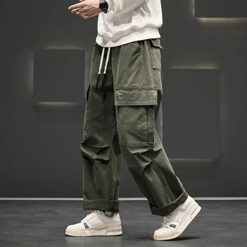 Men's relaxed fit cargo pants in olive green with wide leg silhouette and utility pockets
