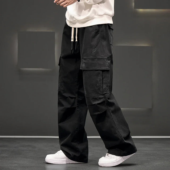 Detail shot of cuffed hem on men's wide leg cargo pants in olive green