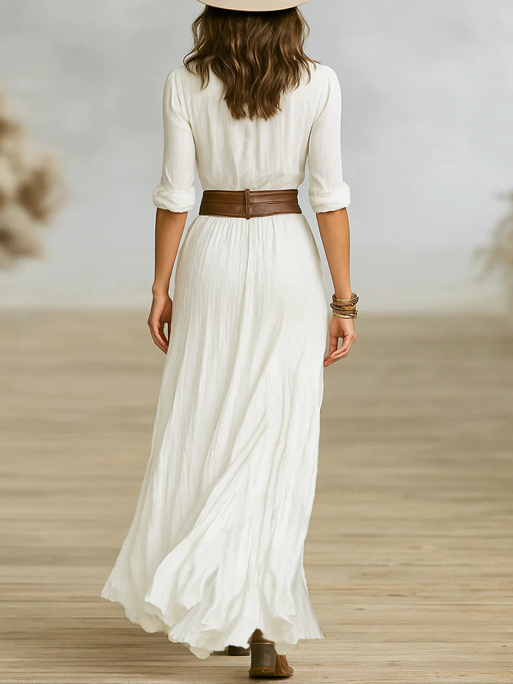 Model wearing button front belted maxi dress demonstrating adjustable roll-tab sleeves and flowing movement