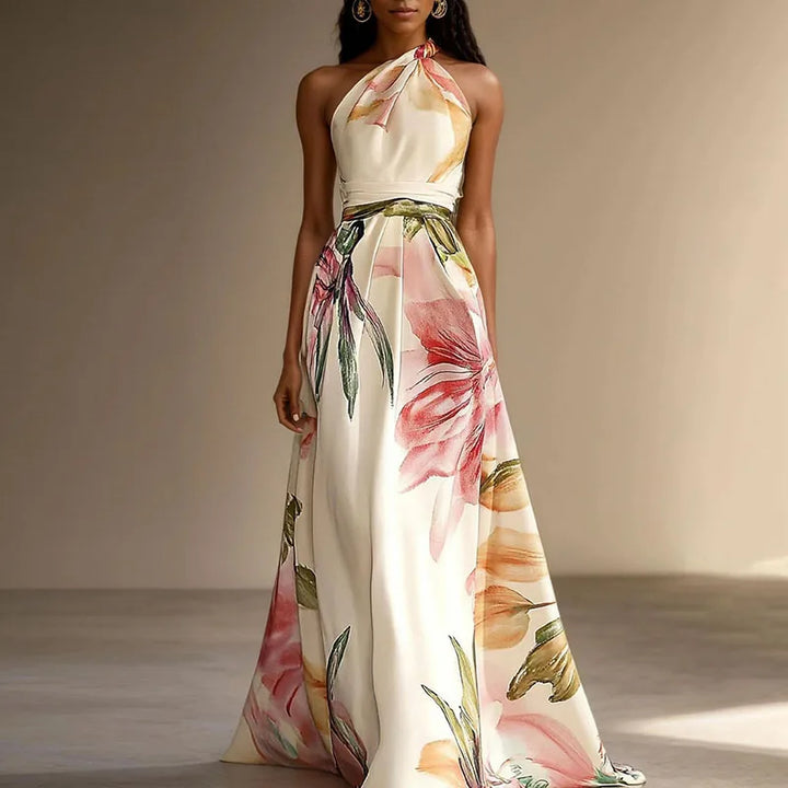 Woman wearing a Floral Wedding Guest Maxi Dress with halter neckline and pink floral print on cream fabric
