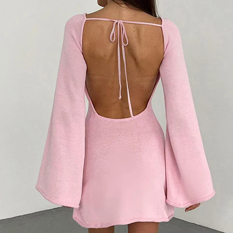 Close view of long-sleeve mini dress showing wide rounded neckline and streamlined fit