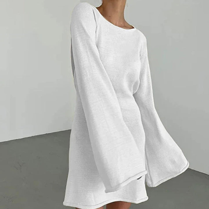 Side angle of mini dress with flared cuffs and smooth fabric finish