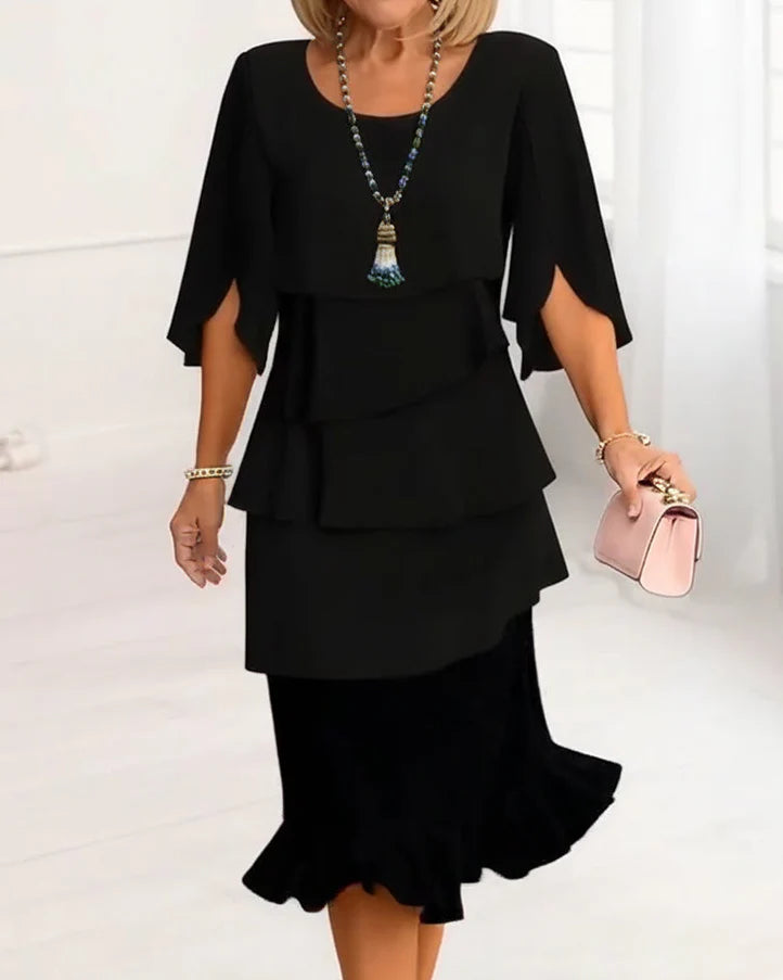 Woman wearing black elegant midi dress with layered ruffles and split flutter sleeves
