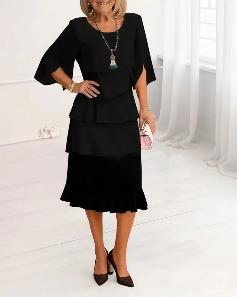 Side view of black midi dress with split sleeves and flowing ruffle layers
