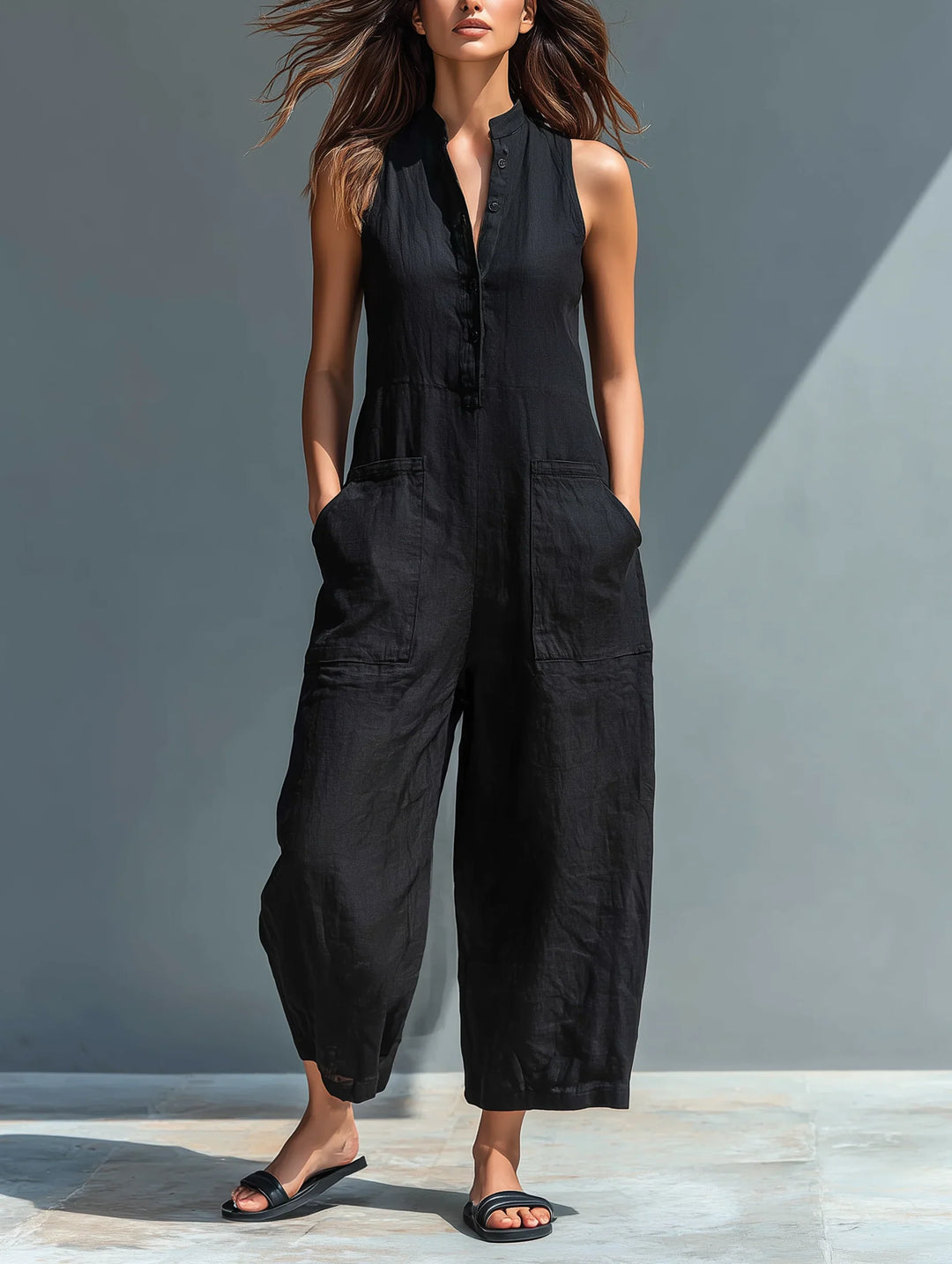 Black sleeveless loose-fitting jumpsuit with stand collar and button-up front closure for women
