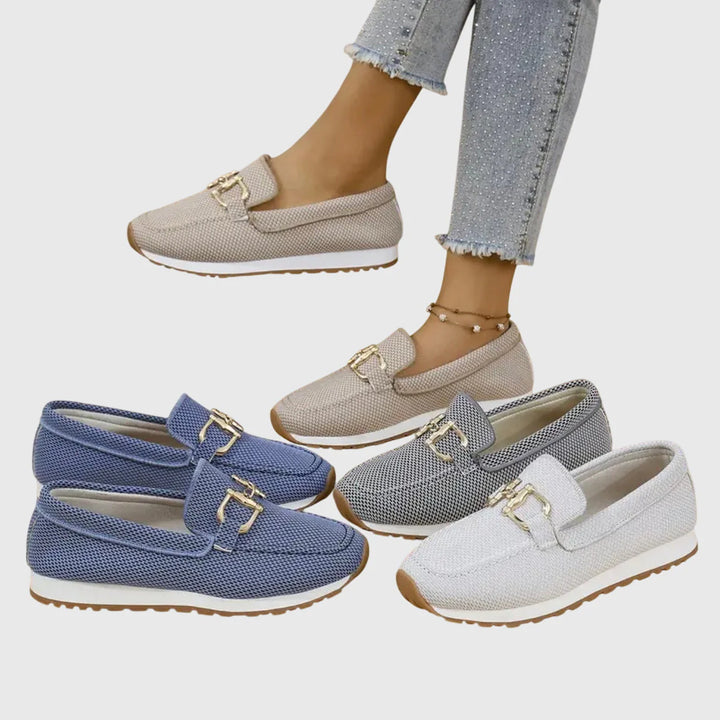 Close-up of women's orthopedic loafers showing gold-tone horsebit hardware and woven canvas texture