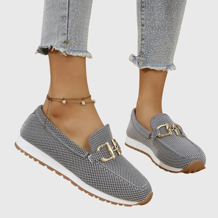 Close-up of women's orthopedic loafers displaying textured canvas upper and gold-tone hardware accent detail