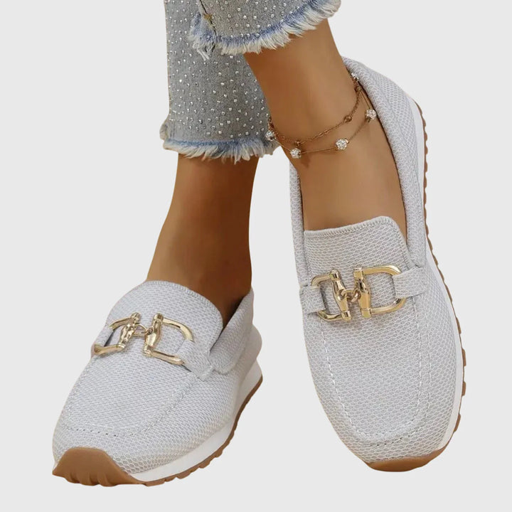 Women's orthopedic loafers worn with cropped jeans showing rounded toe shape and supportive rubber outsole