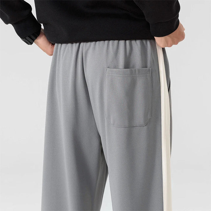 Full length view of men's relaxed fit sweatpants with side stripe and roomy silhouette