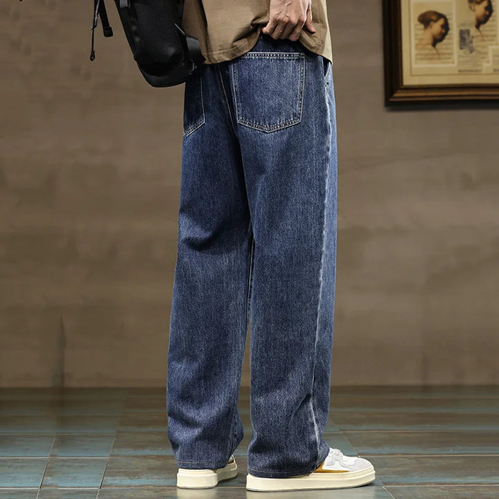 Side view of men's wide leg jeans showing relaxed straight leg silhouette and contrast drawcord detail