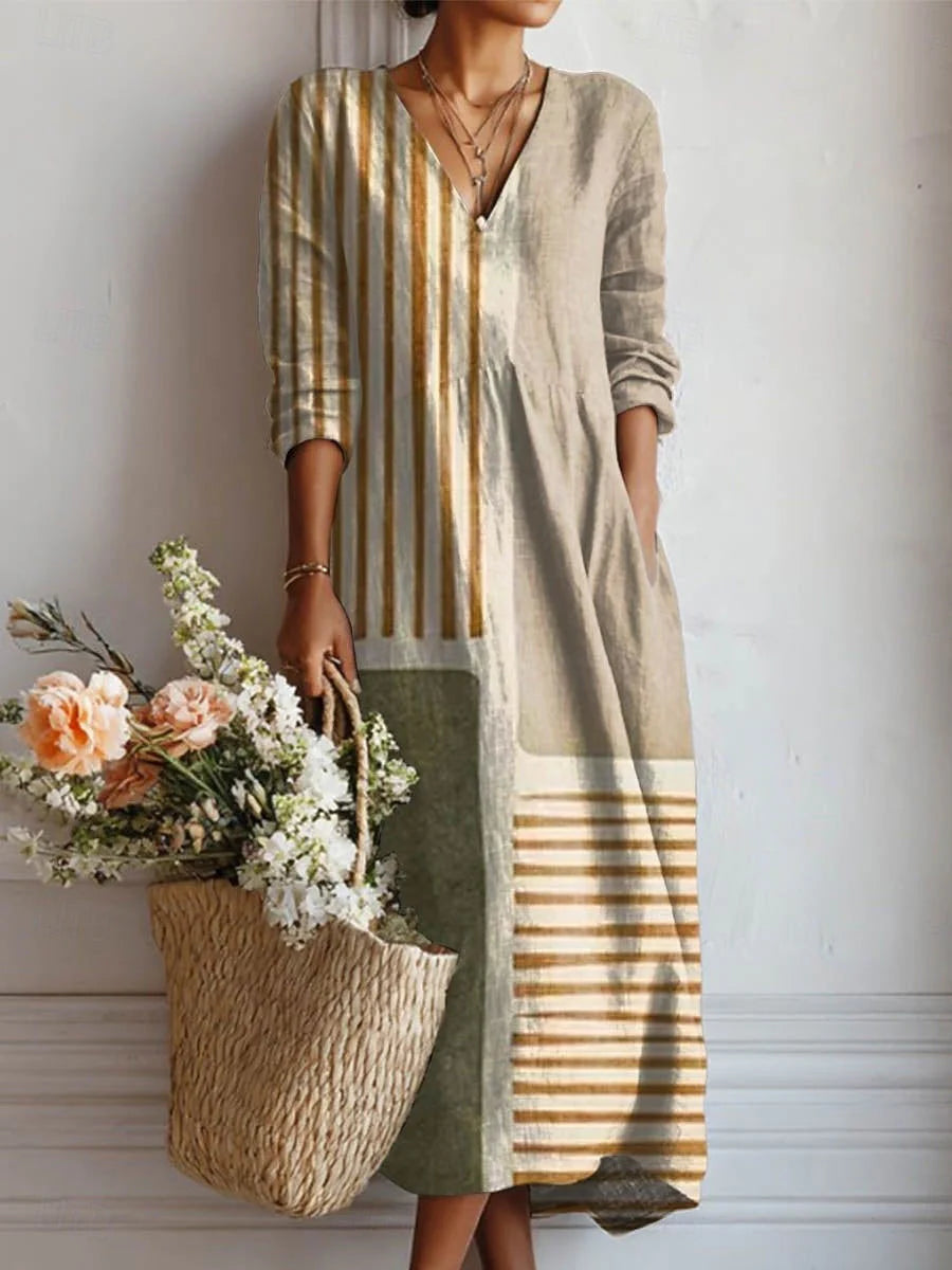 Woman wearing a cotton midi dress with vertical striped panel detail in mustard and sage tones, featuring a V-neckline and three-quarter sleeves