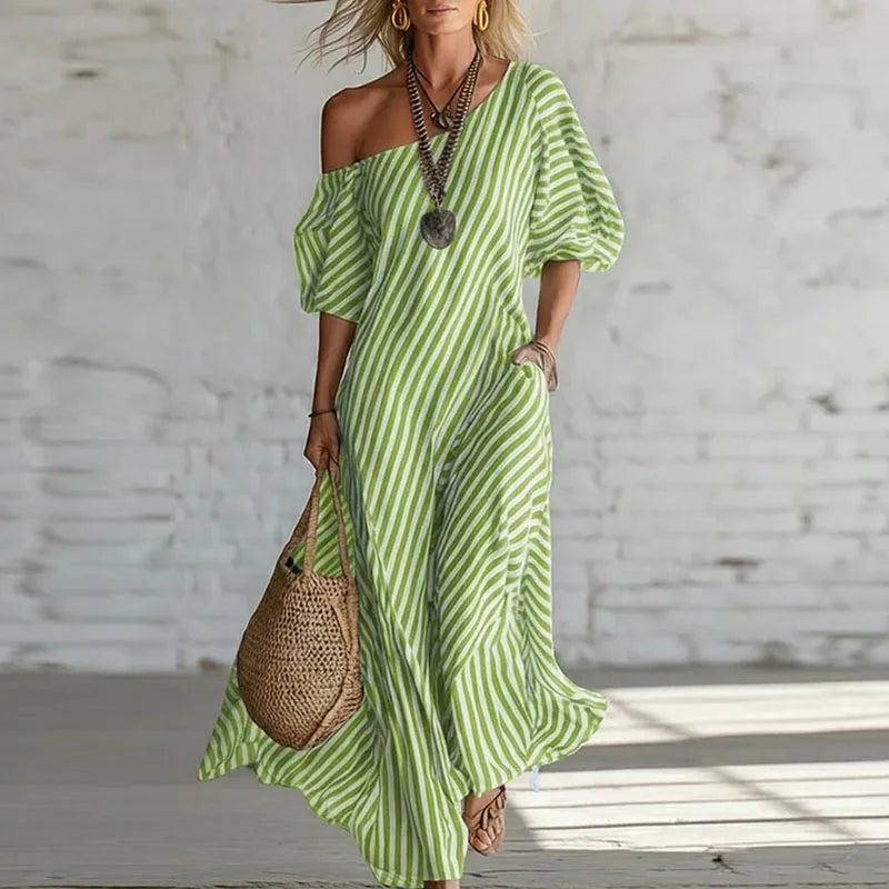 Side view of one shoulder puff sleeve dress showing vertical stripe pattern and relaxed maxi silhouette