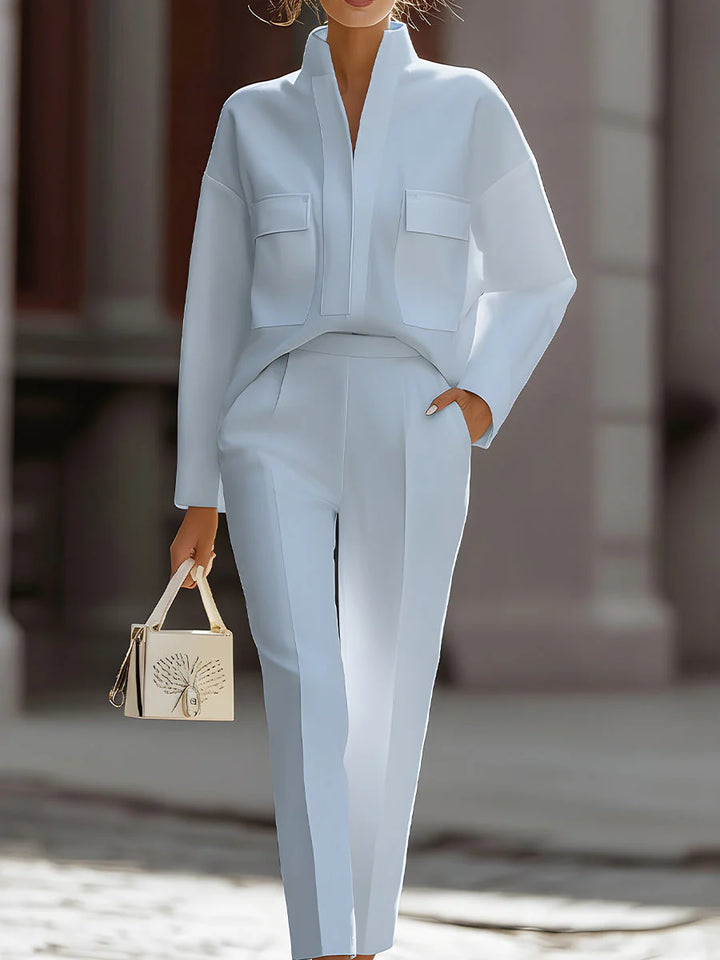 Detail of stand collar and chest flap pockets on oversized shirt paired with high-waisted pants