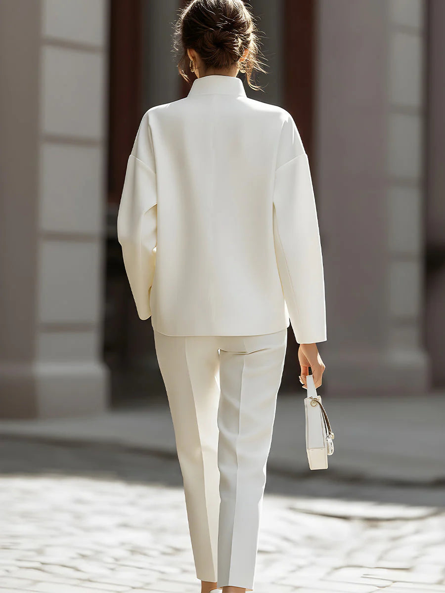Woman styling oversized shirt and pants two-piece set with minimalist accessories and heeled sandals