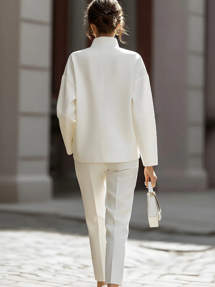 Woman styling oversized shirt and pants two-piece set with minimalist accessories and heeled sandals