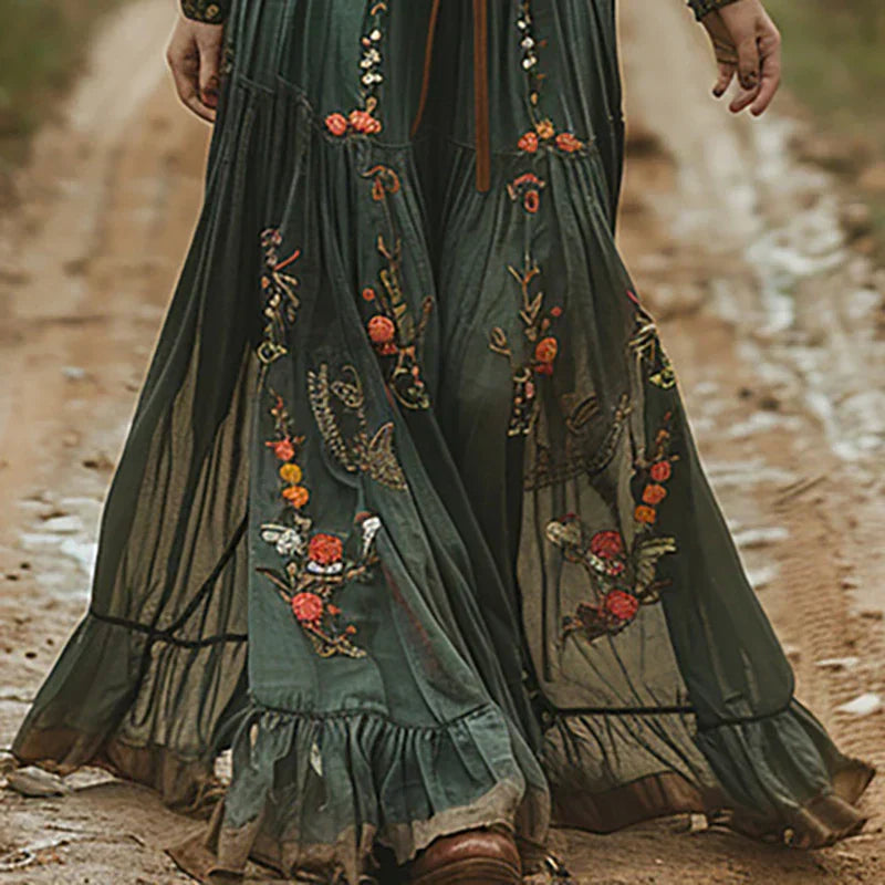 Embroidered maxi dress in dark brown showing bohemian style with sheer sleeves and tiered hem