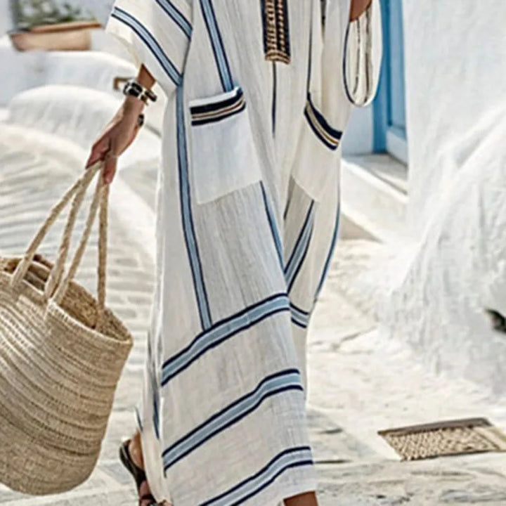 Close-up detail of striped kaftan dress neckline with contrast trim and pocket design