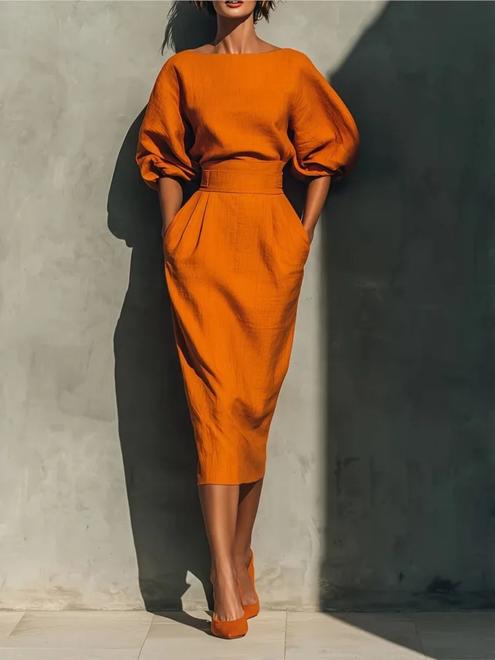 Midi dress with lantern sleeves and cinched waist in vibrant orange pleated skirt design