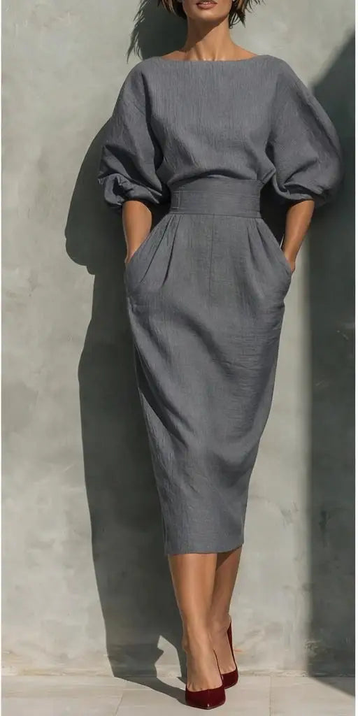 Detail of boat neckline and lantern sleeve construction on structured midi dress