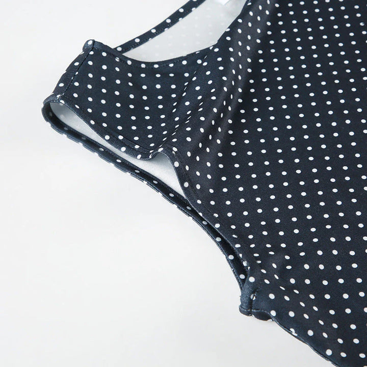 Back view of sleeveless polka dot mini dress blue displaying fitted waist detail