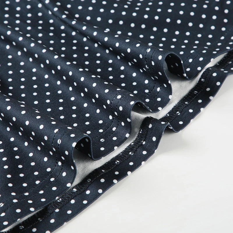 Detail shot of round neckline and sleeveless cut on polka dot mini dress blue