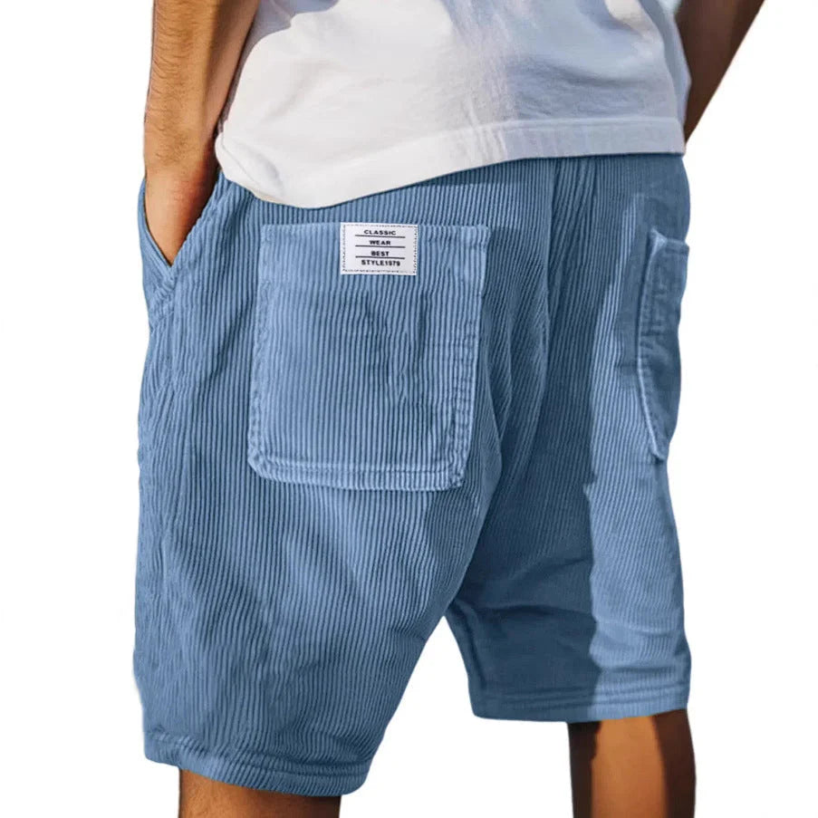 Side angle of relaxed fit cargo shorts displaying mid-thigh length and vertical ribbed fabric texture