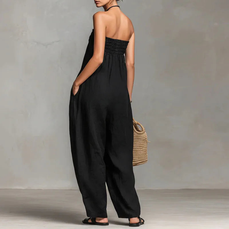 Back view of strapless off shoulder jumpsuit showing wide leg silhouette and flowing drape