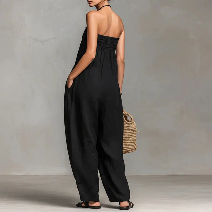 Back view of strapless off shoulder jumpsuit showing wide leg silhouette and flowing drape