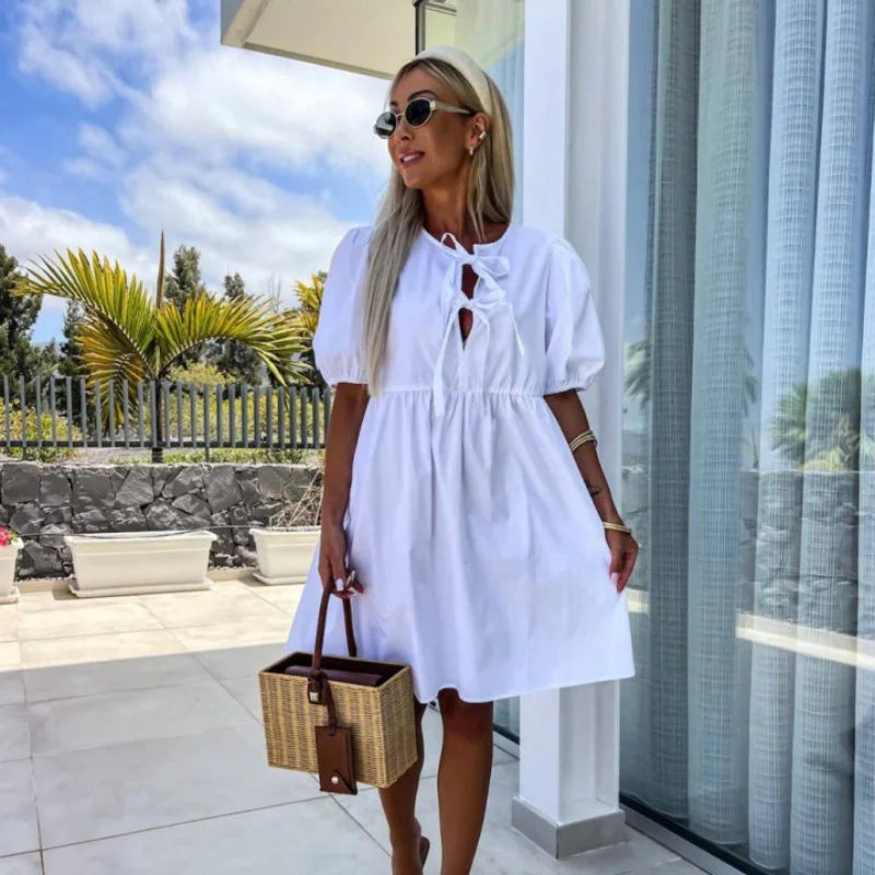 Women's mini dress with bow accents at chest and gathered puff sleeves for casual wear